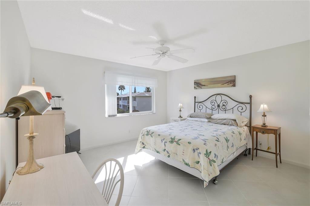 278 Winners Circle, Unit 2672 Naples, FL 34112 - Photo 12 of 17 a bedroom with a bed and a chandelier