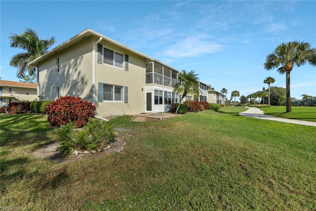 278 Winners Circle, Unit 2672 Naples, FL 34112 - Photo 15 of 17 a front view of a house with a yard
