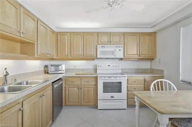 a kitchen with cabinets appliances a sink and a counter top space