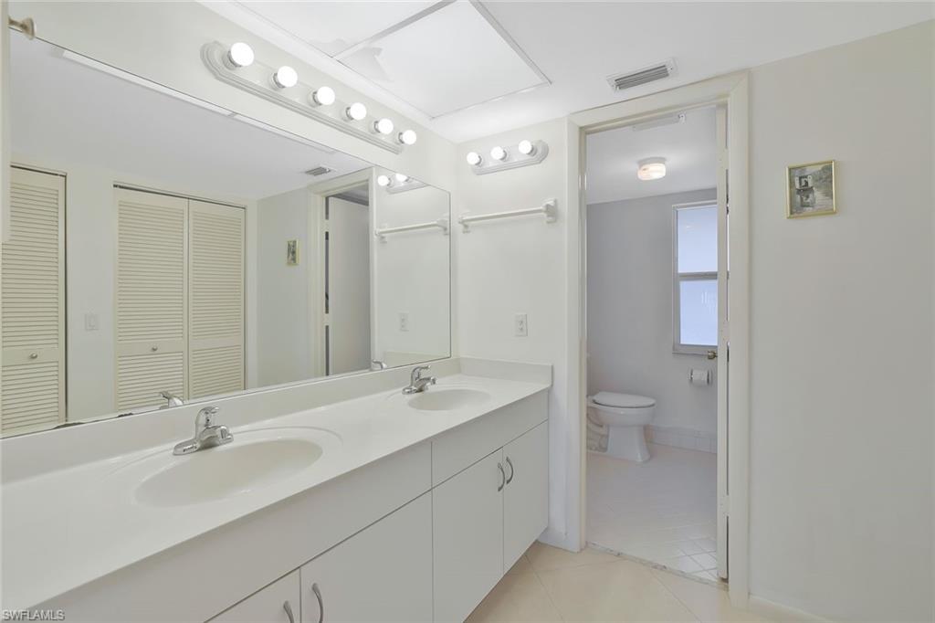 278 Winners Circle, Unit 2672 Naples, FL 34112 - Photo 10 of 17 a bathroom with a double vanity sink mirror and toilet