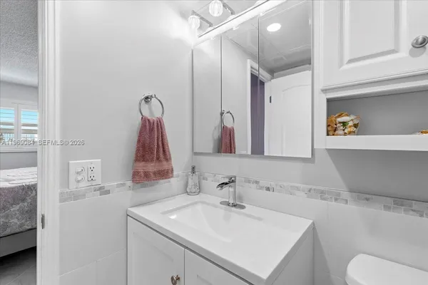 a bathroom with a sink vanity mirror and tub