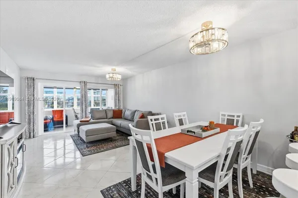 a view of a dining room with furniture a chandelier and a large window
