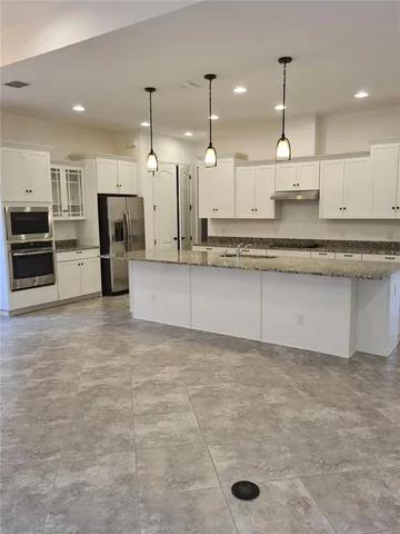 a large kitchen with kitchen island a sink stainless steel appliances and cabinets