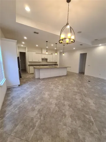 a view of a kitchen with a sink and chandelier