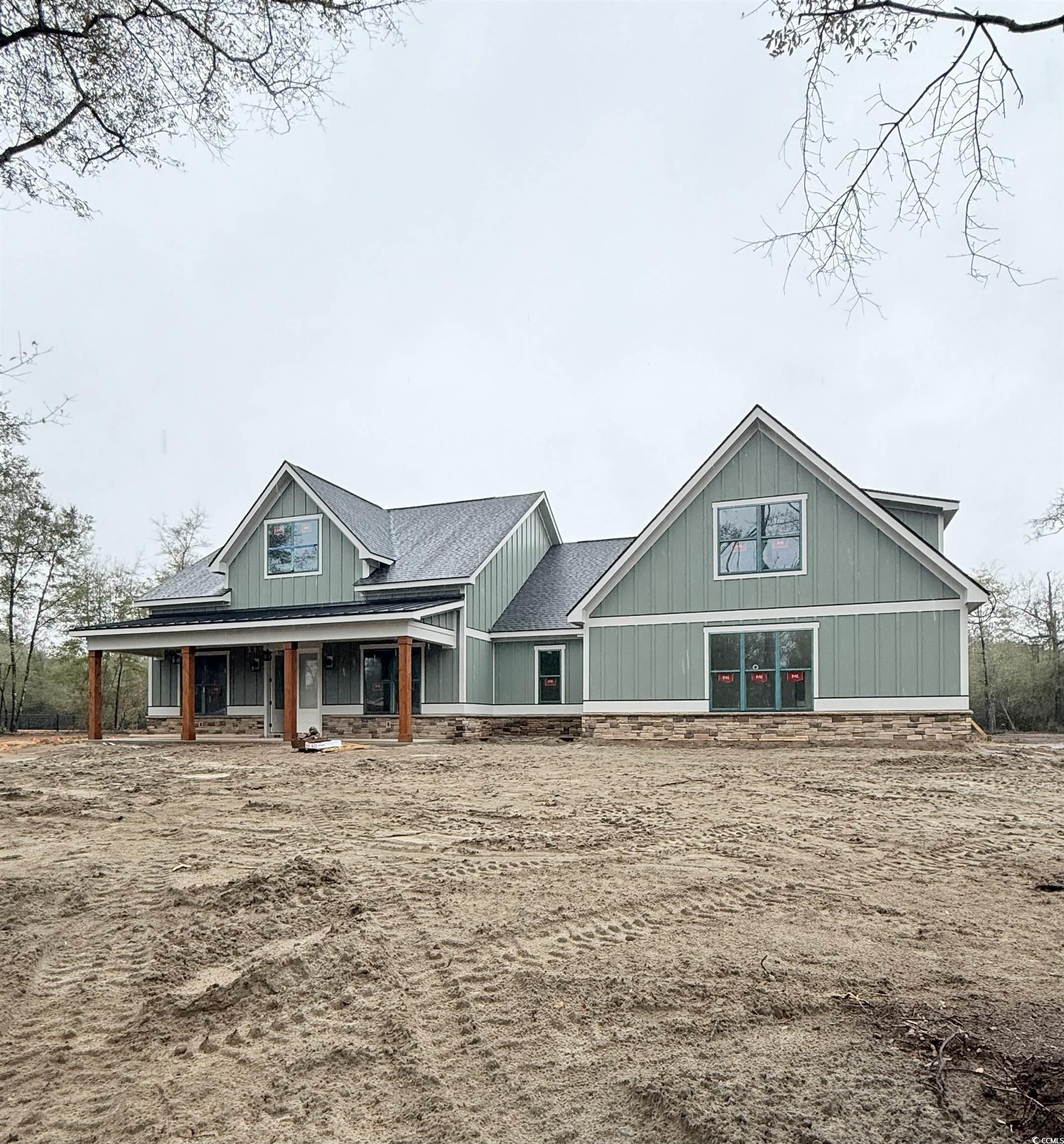 Craftsman house featuring stone siding, board and batten siding, and roof with shingles