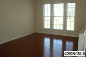 672 6th Baxter Crossing, Unit 1802 Fort Mill, SC 29708 - Photo 2 of 7 an empty room with wooden floor and windows
