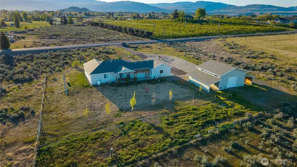 an aerial view of a house with a yard and lake view