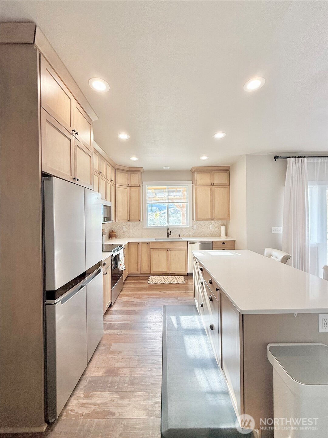 103 Johnson Creek Road Omak, WA 98841 - Photo 20 of 40 a large kitchen with kitchen island a large counter top space a sink stainless steel appliances and cabinets