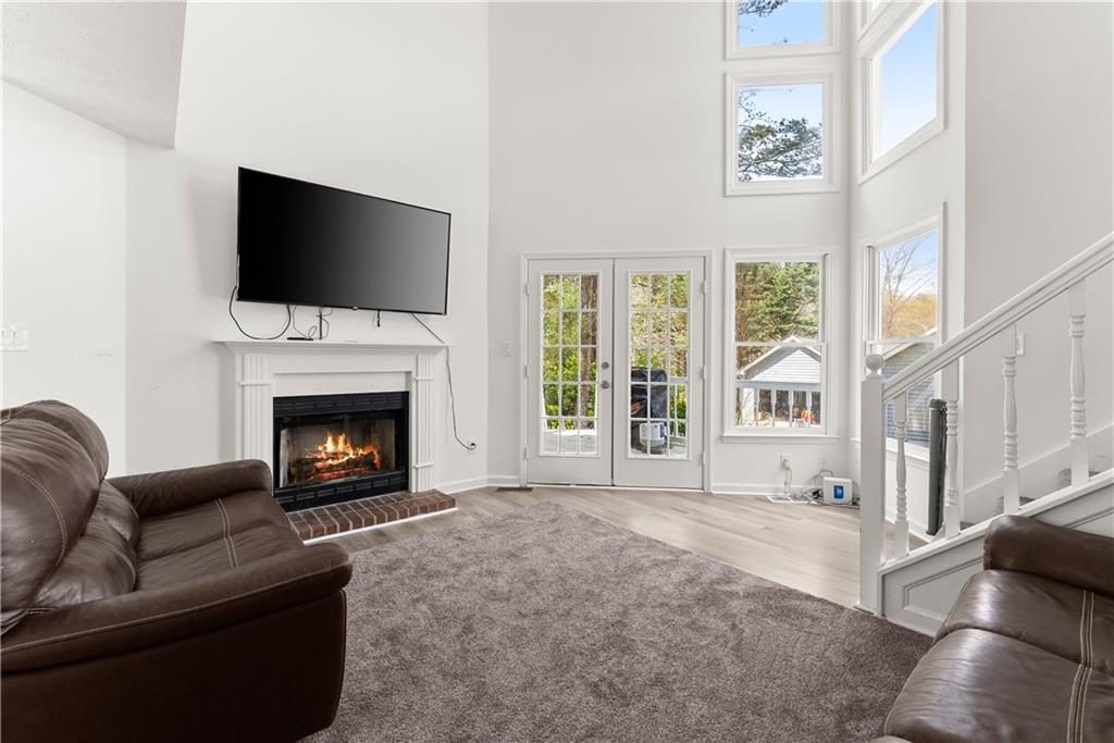 322 Wyngate Road Auburn, GA 30011 - Photo 11 of 44 a living room with furniture a flat screen tv and a fireplace