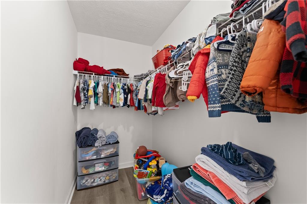 322 Wyngate Road Auburn, GA 30011 - Photo 22 of 44 a view of walk in closet with clothes and shoes