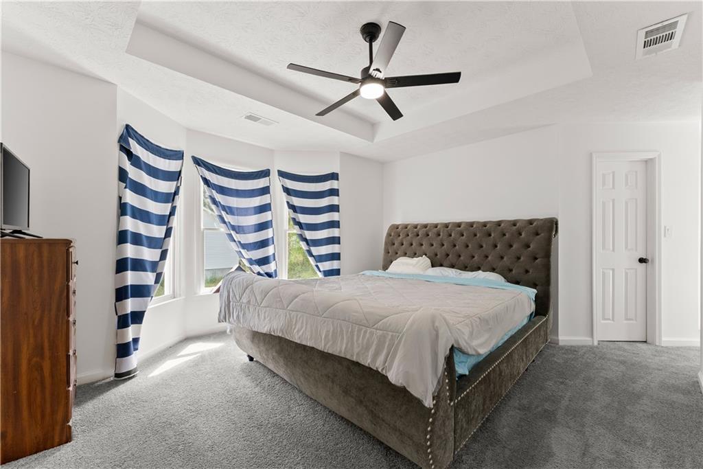 322 Wyngate Road Auburn, GA 30011 - Photo 24 of 44 a bedroom with a bed and a chandelier