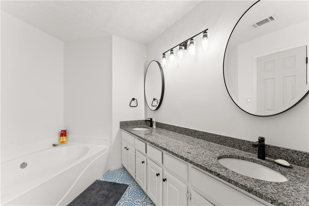 322 Wyngate Road Auburn, GA 30011 - Photo 27 of 44 a bathroom with a granite countertop sink and a mirror