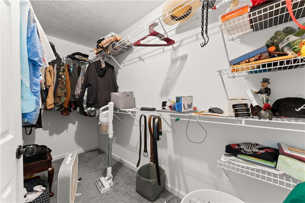 322 Wyngate Road Auburn, GA 30011 - Photo 30 of 44 a view of walk in closet with clothes and shoes
