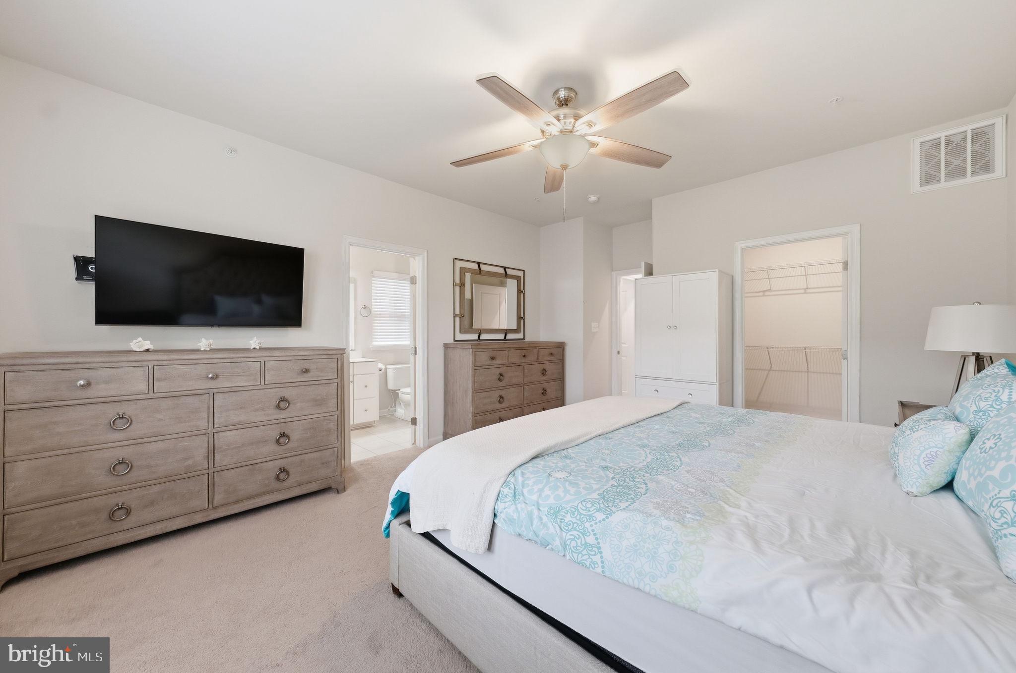 3012 Bretons Ridge Way Hanover, MD 21076 - Photo 17 of 37 a bedroom with a bed a mirror and a flat screen tv