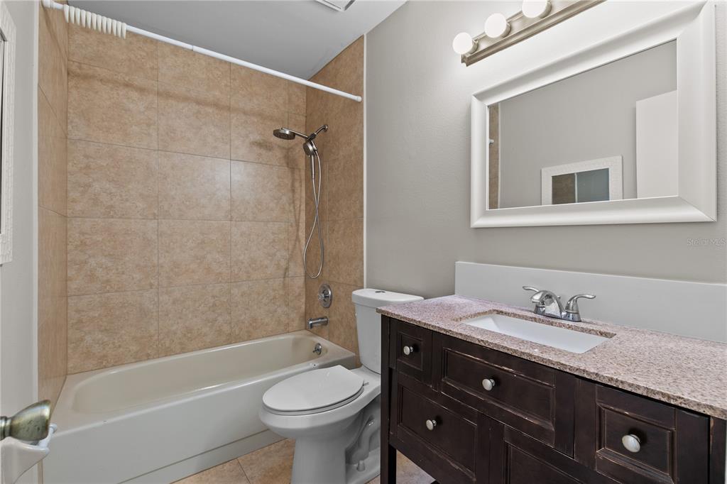 111 Feather Edge Loop, Unit 4B Lake Mary, FL 32746 - Photo 17 of 27 a bathroom with a granite countertop toilet sink and mirror