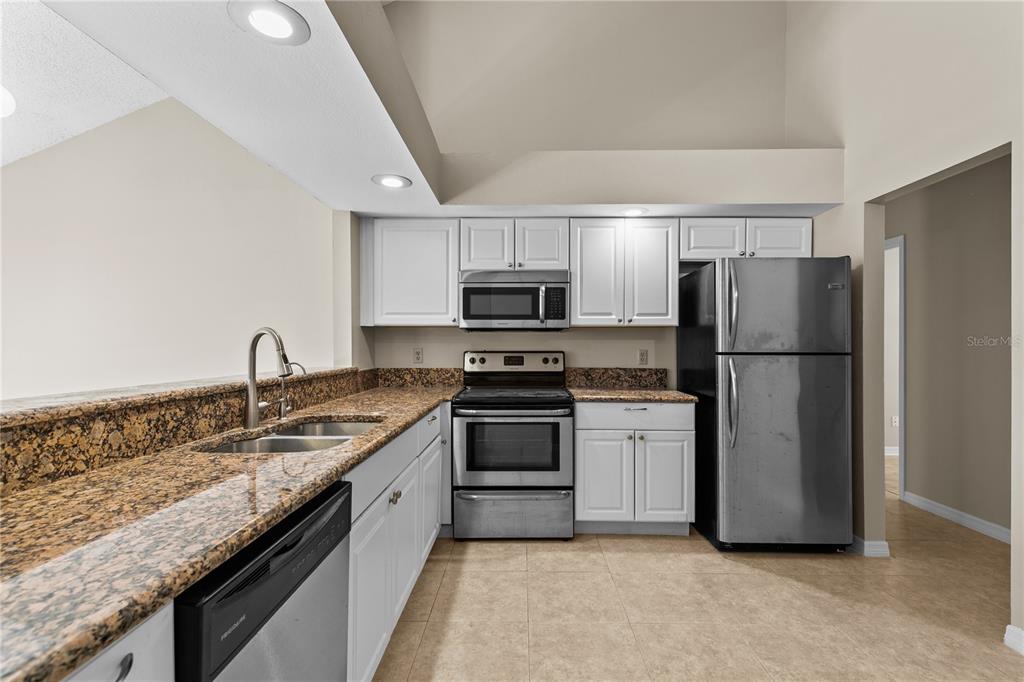 111 Feather Edge Loop, Unit 4B Lake Mary, FL 32746 - Photo 3 of 27 a kitchen with granite countertop stainless steel appliances and a refrigerator