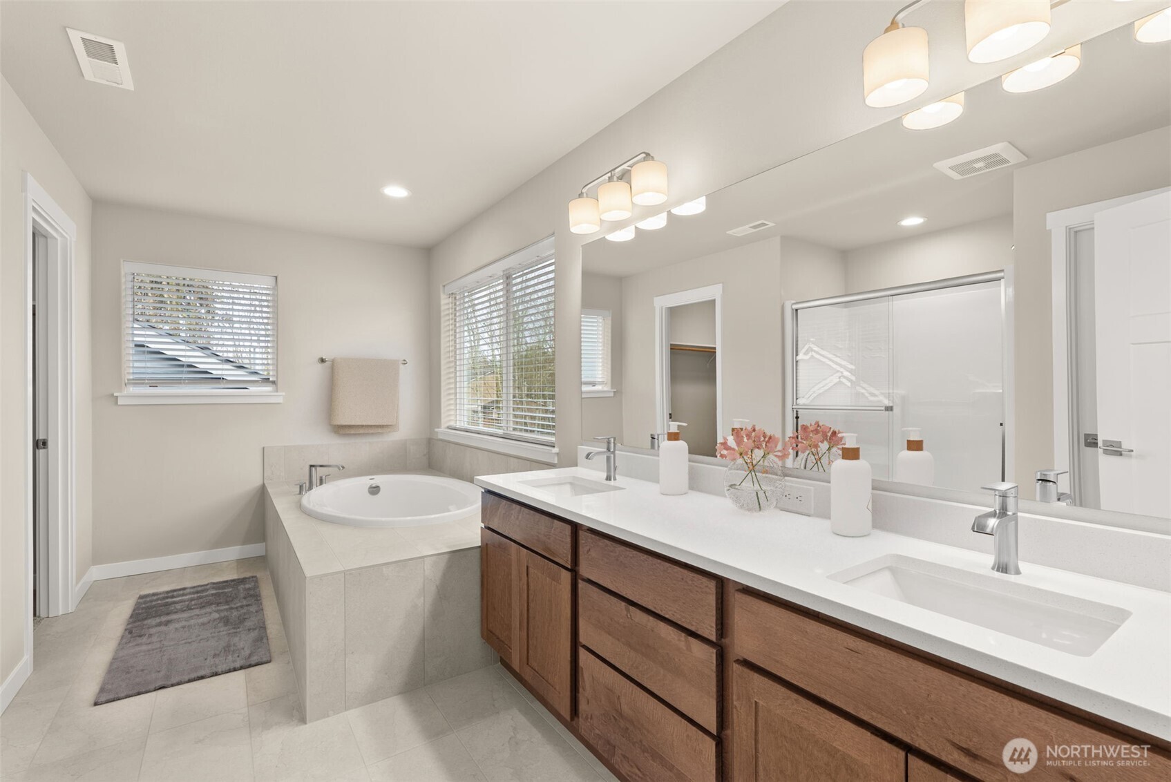 7308 Jenner Street Southwest Tumwater, WA 98512 - Photo 18 of 40 a spacious bathroom with a double vanity sink a large mirror and a bathtub