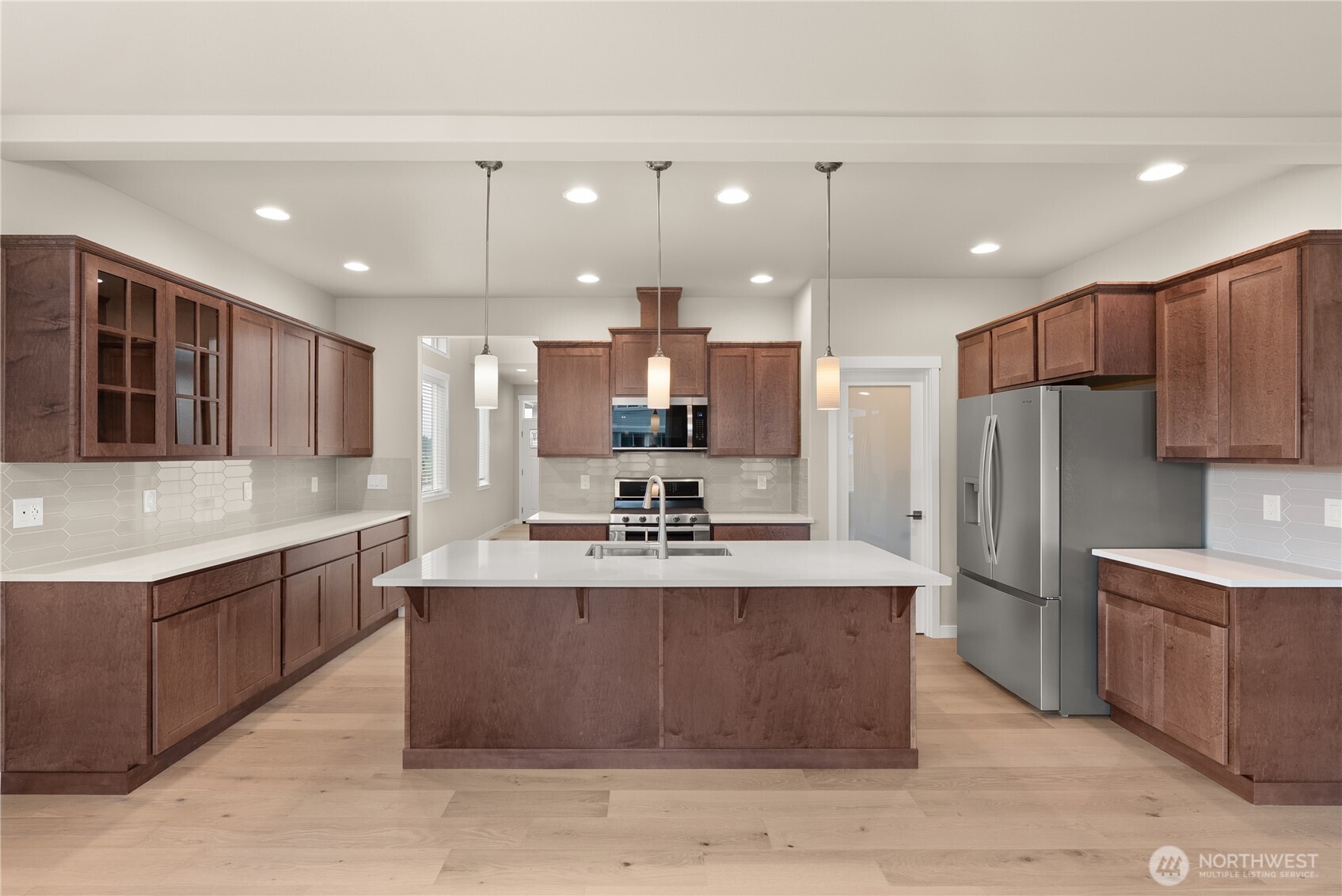 7308 Jenner Street Southwest Tumwater, WA 98512 - Photo 8 of 34 a large kitchen with kitchen island a sink stainless steel appliances and cabinets