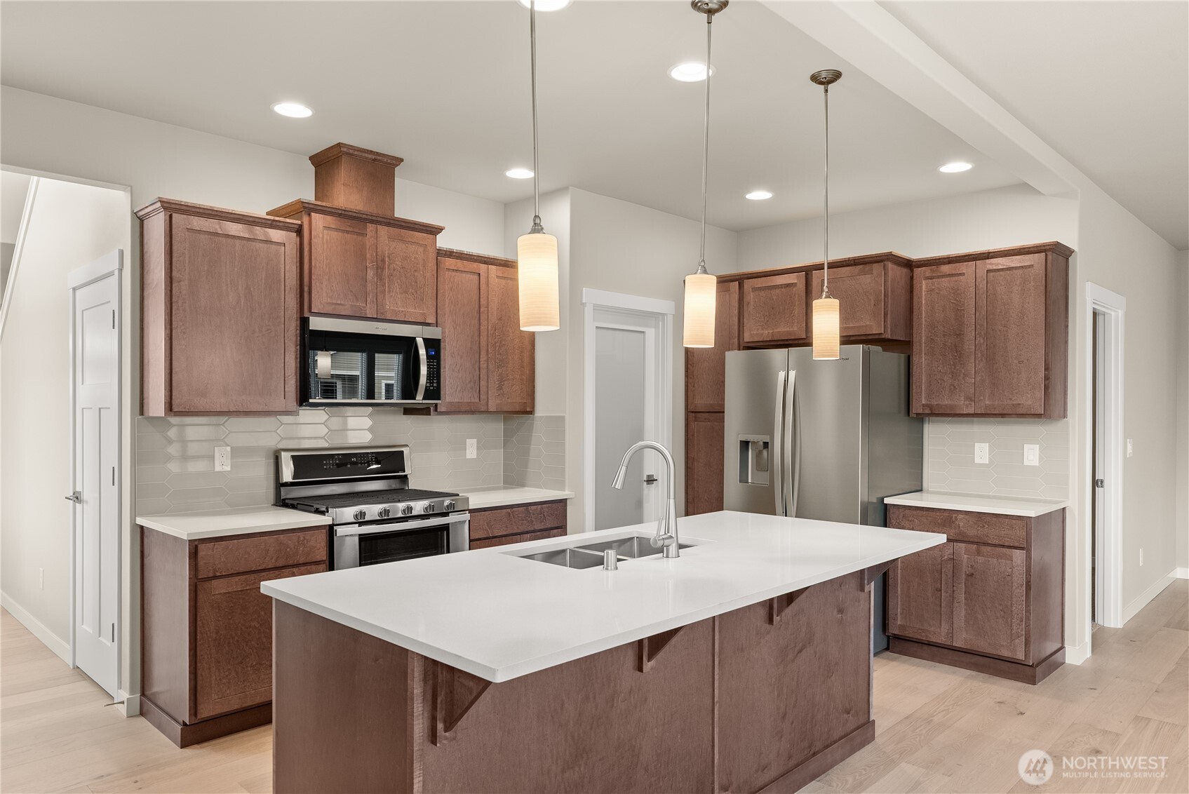 7308 Jenner Street Southwest Tumwater, WA 98512 - Photo 9 of 34 a kitchen with stainless steel appliances kitchen island a sink table and chairs