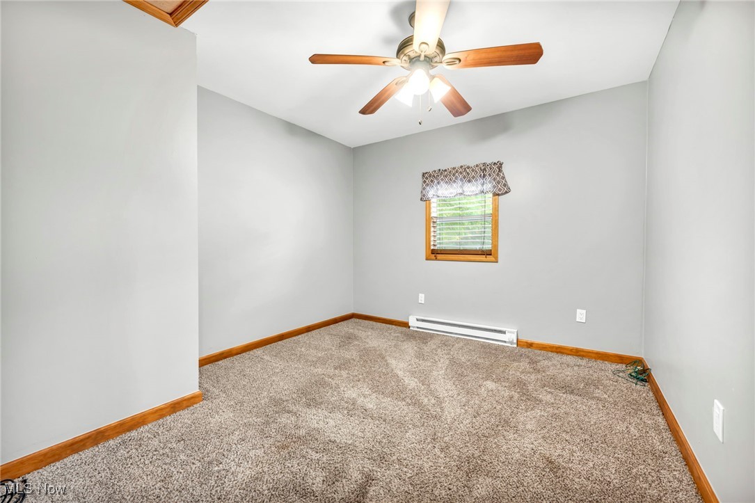 6081 Laskey Road Rome, OH 44085 - Photo 17 of 25 Carpeted empty room featuring ceiling fan and a baseboard heating unit