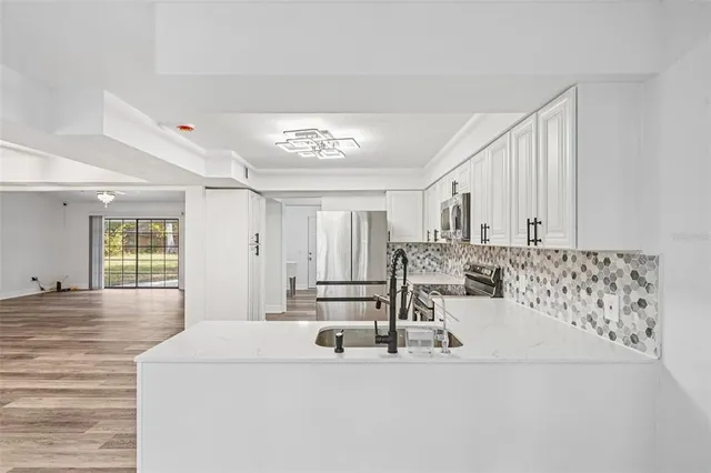 a kitchen with a refrigerator a sink and cabinets
