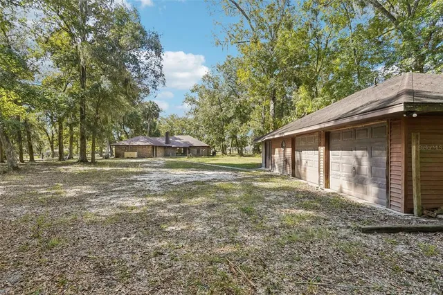 a view of a house with backyard and trees