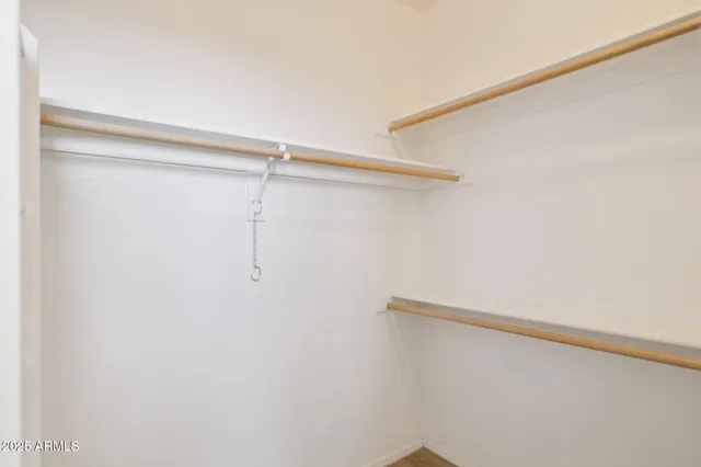 an empty room with wooden floor and a bathroom