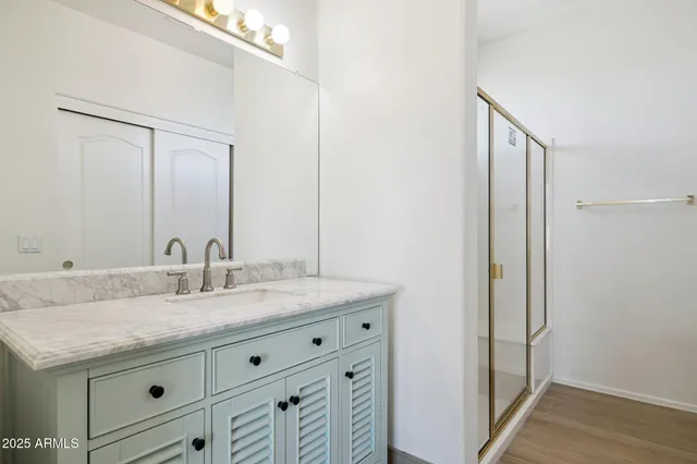 an empty room with wooden floor and a ceiling fan