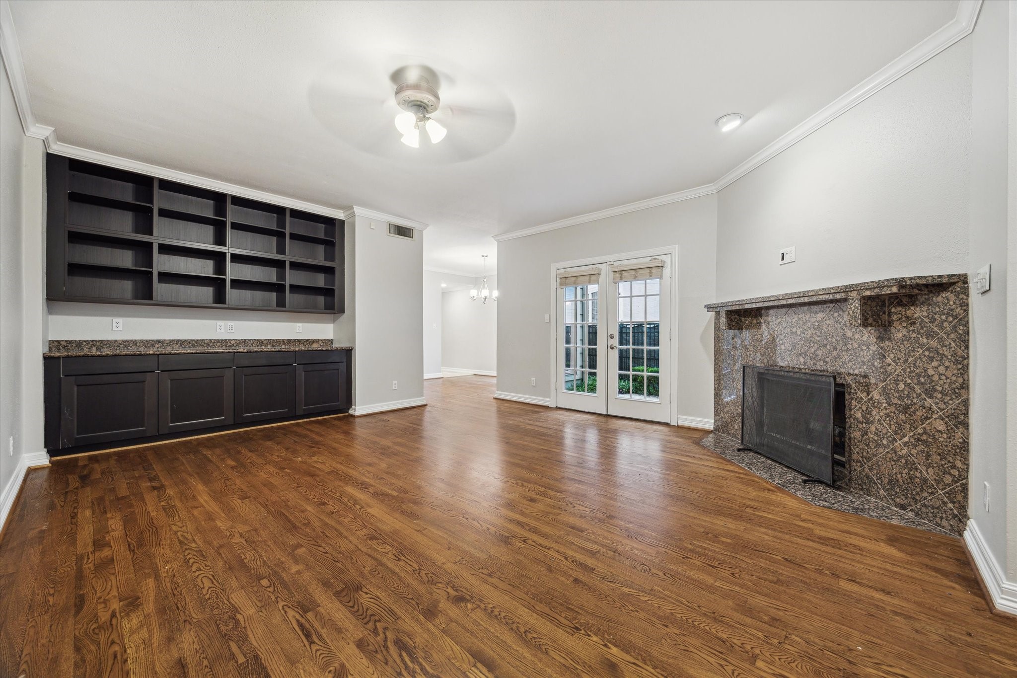 6310 Arnot Street Houston, TX 77007 - Photo 8 of 21 Large living room with hardwoods, French doors, gas fireplace, built in bookshelves and cabinet. The shelves are great for artifacts and books and the bottom cabinet can be set up as a bar and buffet for entertaining.