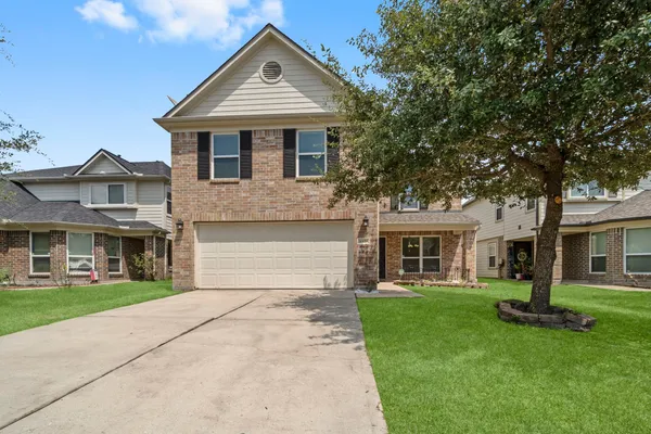 a front view of a house with a yard and trees