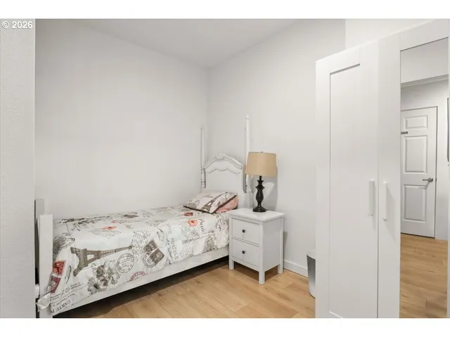 a bedroom with a bed and wooden floor