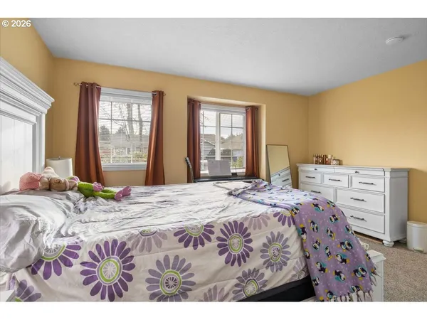 a bedroom with a bed that has a blanket on it and next to a window