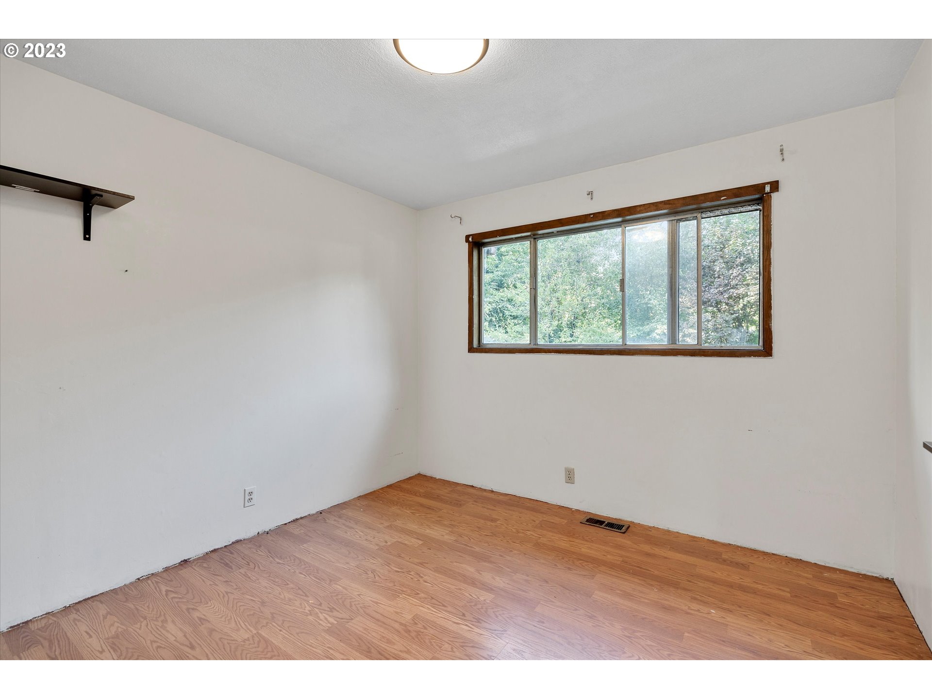 495 Southwest Grove Road Estacada, OR 97023 - Photo 18 of 39 an empty room with wooden floor and windows
