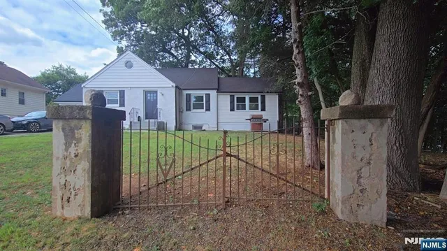 a view of a house with a small yard and a large tree