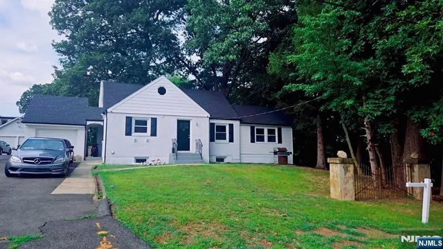a front view of a house with a yard and trees