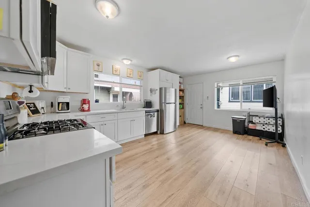 a kitchen with stainless steel appliances a refrigerator sink and cabinets
