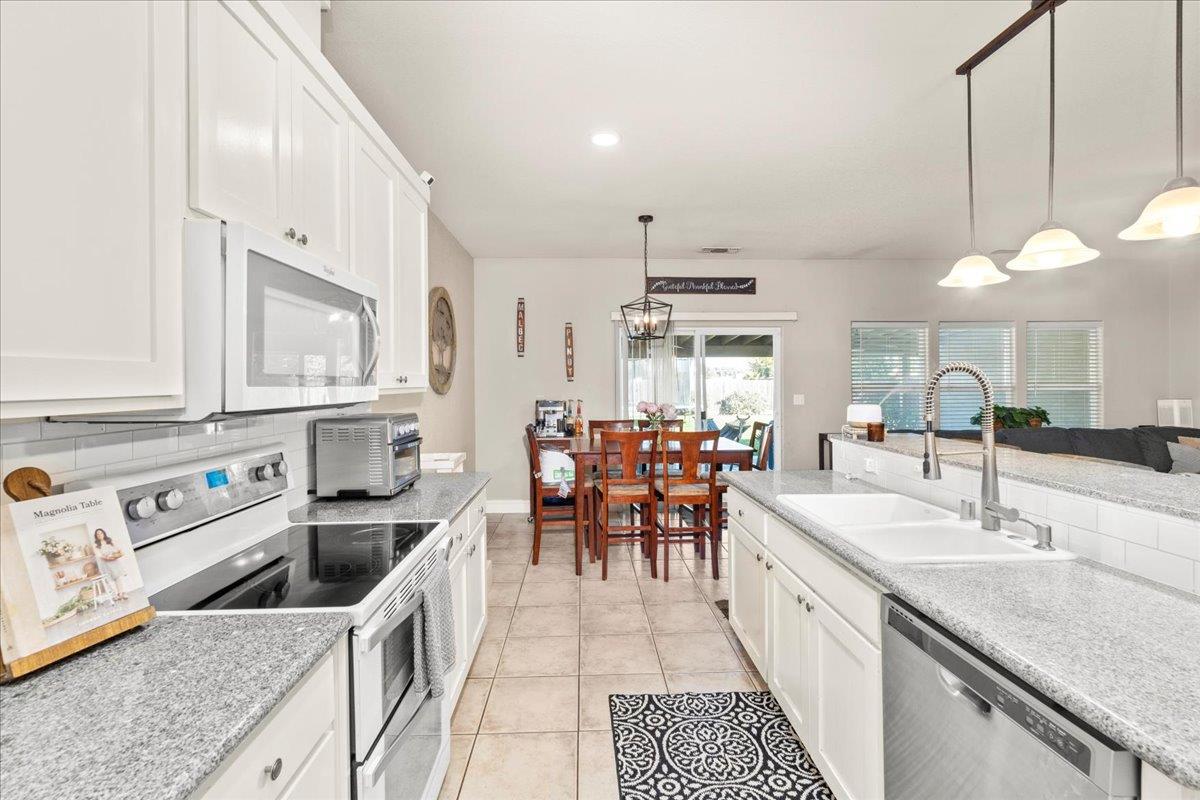 1725 Stonum Road Modesto, CA 95351 - Photo 12 of 34 a kitchen with stove a sink and cabinets