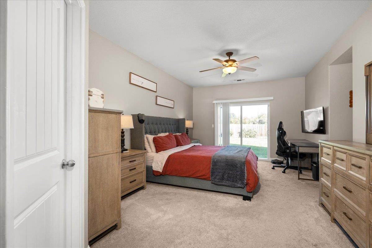1725 Stonum Road Modesto, CA 95351 - Photo 14 of 34 a bedroom with a bed and a chandelier