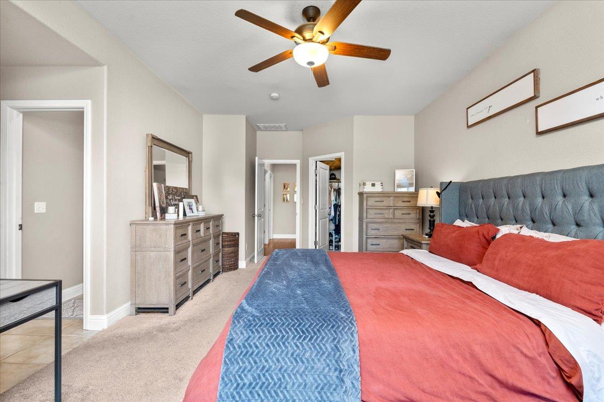1725 Stonum Road Modesto, CA 95351 - Photo 15 of 34 a bed room with a bed and a chandelier
