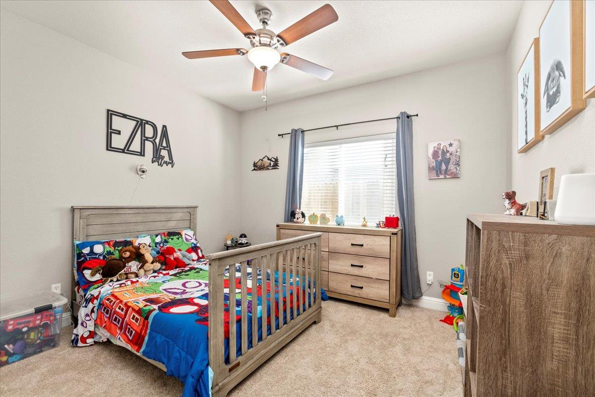1725 Stonum Road Modesto, CA 95351 - Photo 20 of 34 a bedroom with furniture a baby crib and a window