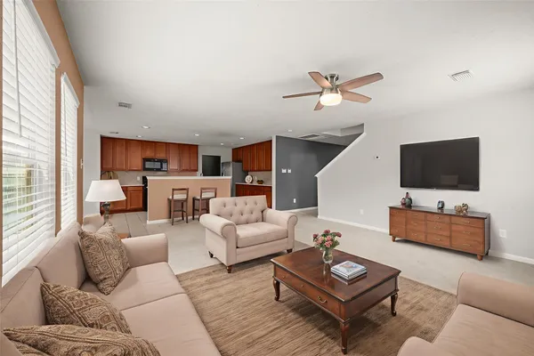 a living room with furniture a flat screen tv and a large window