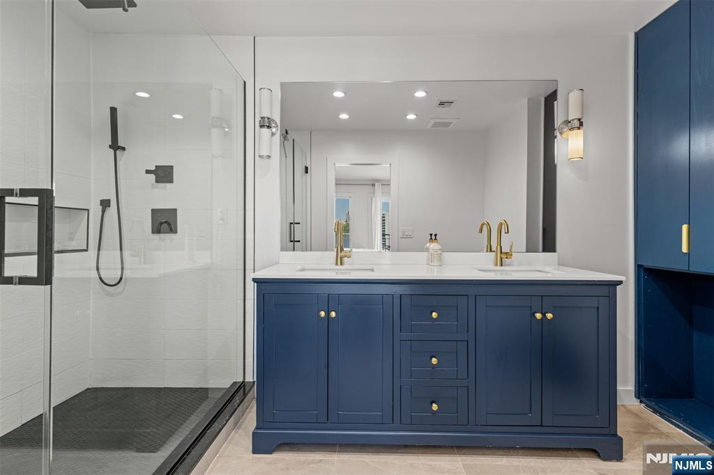 7 Oakdene Terrace, Unit 7 Edgewater, NJ 07020 - Photo 19 of 30 a bathroom with a sink a toilet a large mirror and shower