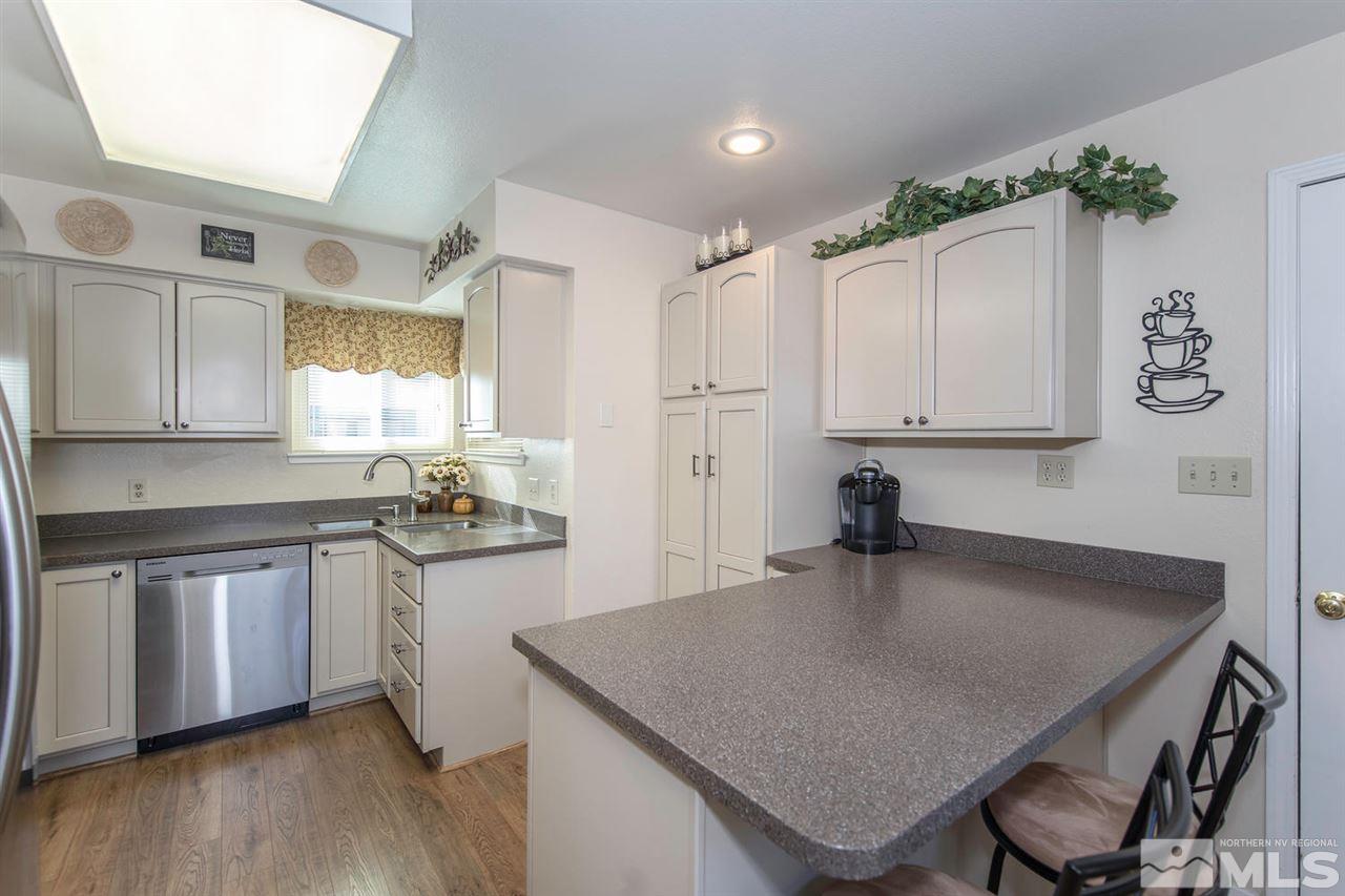 2264 Escalera Way Reno, NV 89523 - Photo 11 of 25 a kitchen with granite countertop a table chairs stove and cabinets