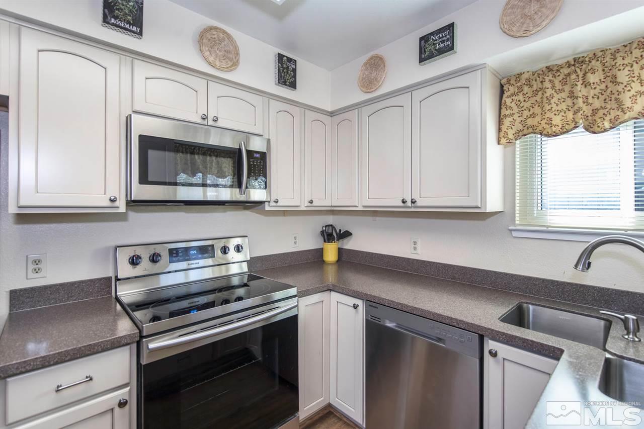 2264 Escalera Way Reno, NV 89523 - Photo 10 of 25 a kitchen with stainless steel appliances granite countertop a sink a stove a microwave and cabinets