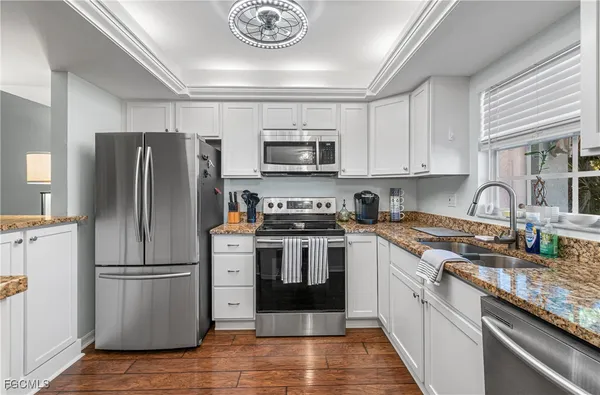 a kitchen with stainless steel appliances granite countertop a stove top oven a refrigerator and a sink