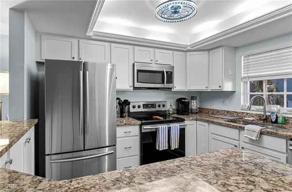 a kitchen with stainless steel appliances granite countertop a refrigerator stove and microwave