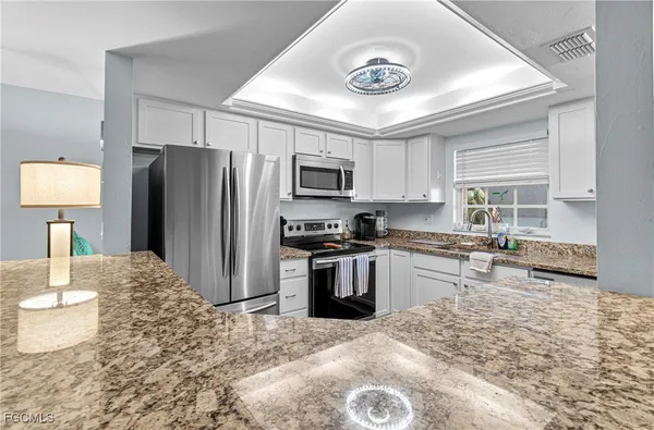 a kitchen with stainless steel appliances granite countertop a stove refrigerator and microwave