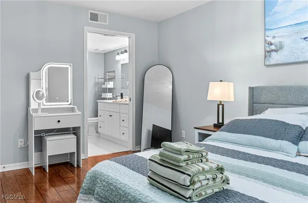 a spacious bedroom with a bed and wooden floor
