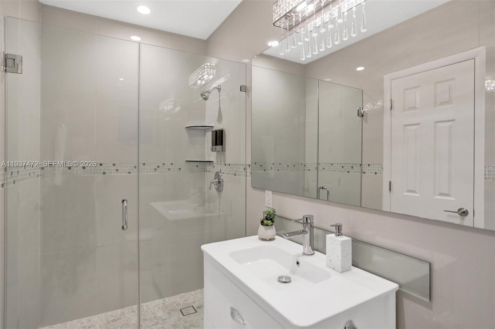 8843 Hawthorne Avenue Surfside, FL 33154 - Photo 15 of 28 a bathroom with a sink a shower a mirror and a shower