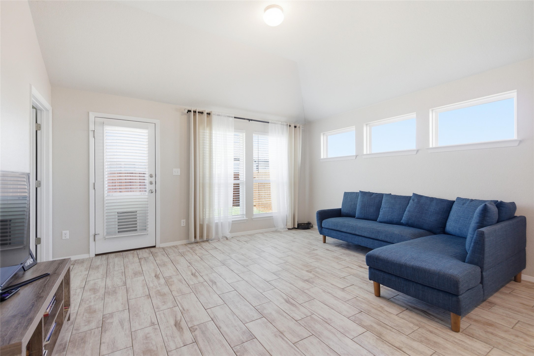 269 Gaida Loop Georgetown, TX 78628 - Photo 9 of 20 Living room featuring vaulted ceiling and wood tiled floors